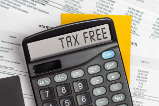 Calculadora sobre papeis de contas e um bloco de notas. No visor dela está escrito 