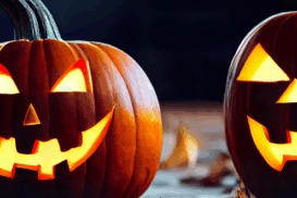 Duas abóboras esculpidas com rostos sorridentes e iluminadas por dentro, sobre folhas secas, representando o espírito do Halloween.